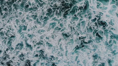 Top down aerial view from above of dark foam white ocean waves foaming on empty Video stock 250253396