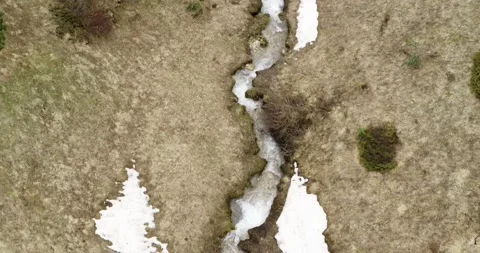 Top down Aerial view of alpine stream in spring, snow melting in the mountain Stock Footage 132119962