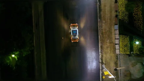 Top down aerial view: Asphalt laying. in the night city. Asphalt paver rides on 스톡 동영상 113998310