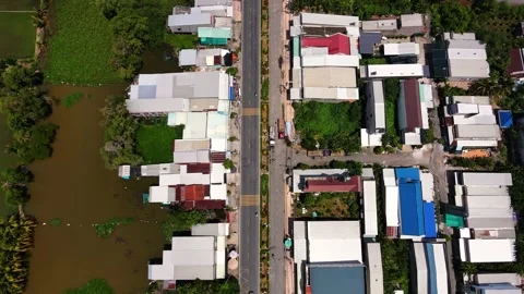 Top-down aerial view of asphalt road passing through small rural village Stock-Footage 342390507