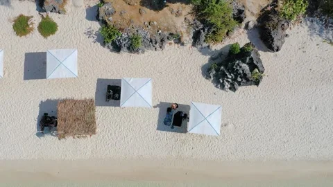Top-down aerial view of beach umbrellas on white sand Stock Footage 325670555