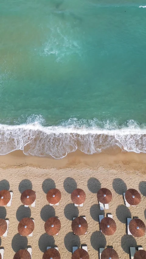 Top Down Aerial View of Beach Umbrellas on Sandy Coast and Sea Stock Footage 340391548