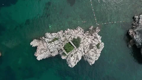 Top down aerial view big stone with old building in the sea next to Przno Stock Footage 246391150