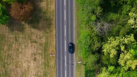 Top-Down Aerial View Of Black Car Driving On Rural Road Vídeos de archivo 334327112
