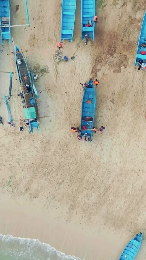 Top-down aerial view of blue fishing boats and local activity along a wide .. Vídeo Stock 341543913