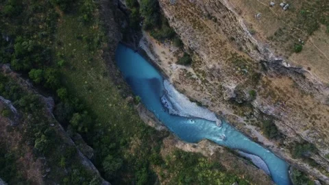 Top down aerial view of bright turquoise river flowing through deep rocky canyon 库存影片 334324287