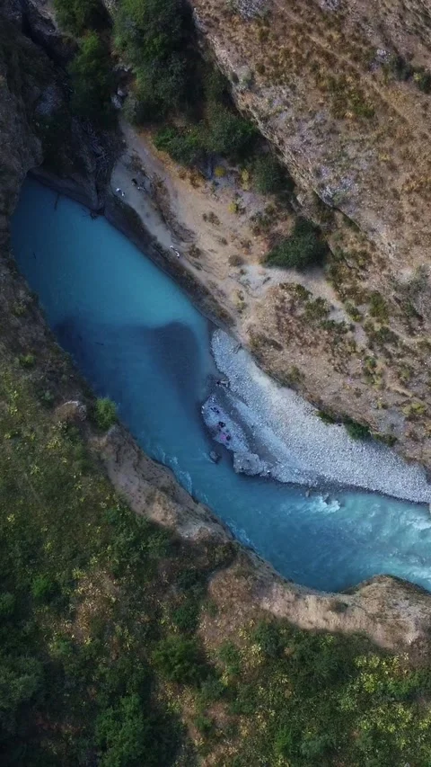 Top down aerial view of bright turquoise river flowing through deep rocky canyon 스톡 동영상 336690180