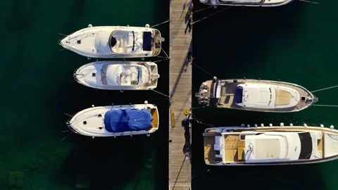 Top down aerial view captures a large marina green water with many sailboats Stock Footage 327012084