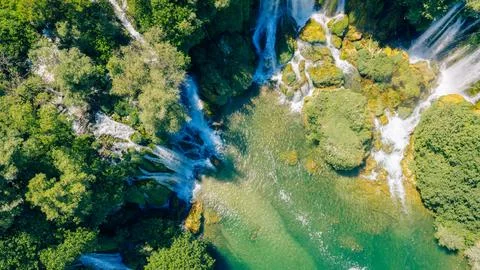 Top down aerial view of cascading waterfalls flowing into emerald pools 写真素材