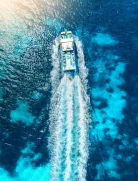 Top down aerial view of catamaran boat cruise in turquoise sea Stock Photos