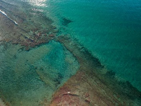 Top Down Aerial View of Clear Turquoise Sea with Submerged Rocks Stock Photos