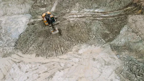 Top-down aerial view of a construction excavator operating on a muddy. Stock Footage 311785220