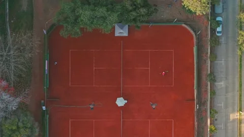 Top down aerial view of a couple playing tennis on a clay court on a sunny day Stock Footage 339128987