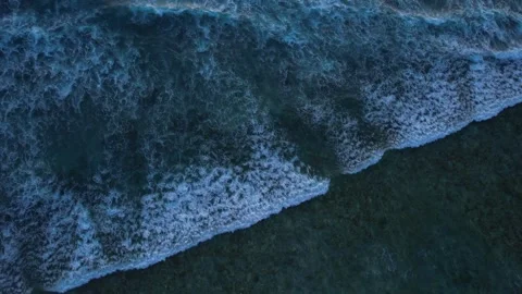 Top down aerial view of crashing ocean waves, drone is slowly hovering in the Stock Footage 256152196