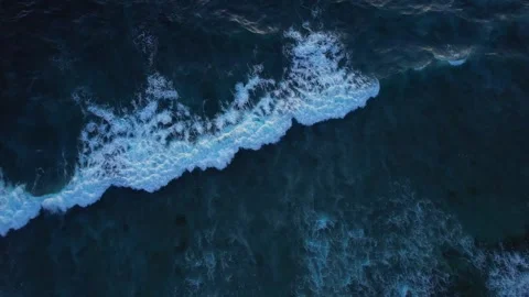 Top down aerial view of crashing ocean waves, drone is slowly hovering in the Stock Footage 256219528