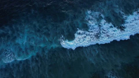 Top down aerial view of crashing ocean waves, drone is slowly hovering in the Stock Footage 260196596