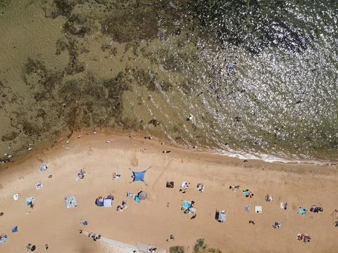 Top down aerial view of crowded sandy beach Stock Photos