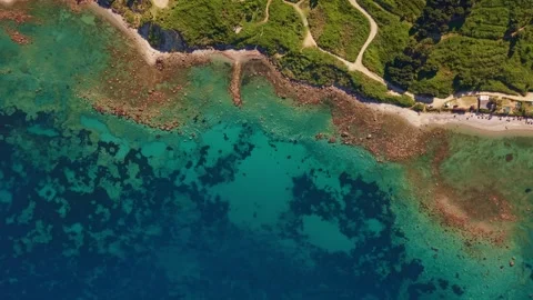 Top down aerial view of crystal clear turquoise sea and rocky shore Stock Footage 337792038