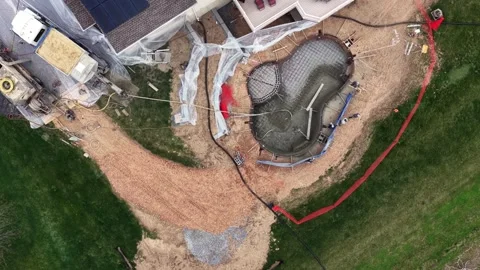 Top-down aerial view of custom gunite swimming pool construction in suburban Stock Footage 333330590