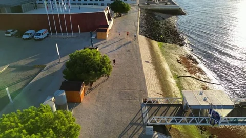 Top-down aerial view of a cyclist riding along Lisbon waterfront as the camera Stock Footage 348619084