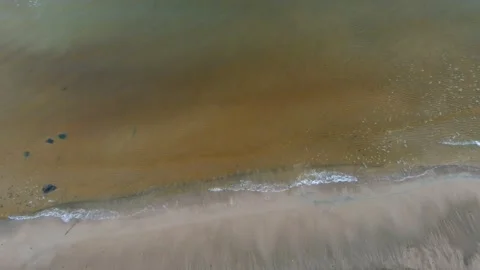 Top down aerial view from drone of calm sea waves crashing and foaming on rock Stock-Footage 143486539