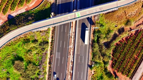 Top-down aerial view of dual carriageway with cars on red soil plain, Spain Vídeo Stock 337463950