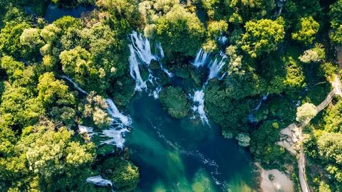 Top down aerial view of emerald pools beneath spectacular cascading waterfall Stock Photos