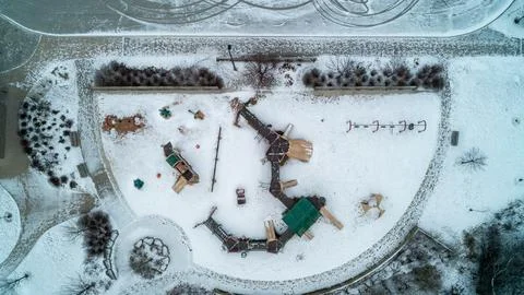 Top Down Aerial View of Empty Park Playground and Swings in Winter Snow Stock Photos