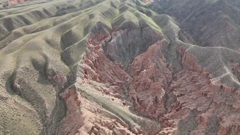 Top-down aerial view of eroded red gullies and badlands, Kyrgyzstan Видео 347239517