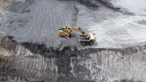 Top down aerial view of excavator operating near excavation edge inside mining Video stock 329394929