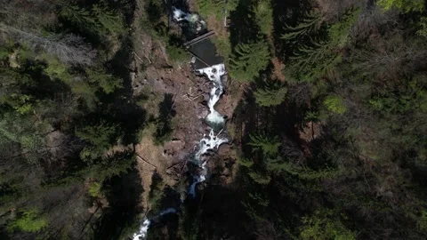 Top down aerial view following a natural river ending in a huge waterfall Video stock 186925548