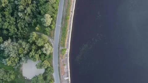 Top down aerial view of forest, road and dark river. 스톡 동영상 311957192