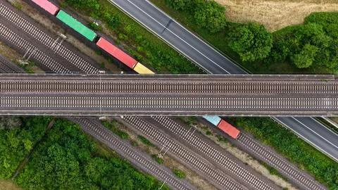 Top-Down Aerial View of Freight Rail Junction and Road Bridge Stock Photos
