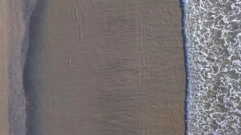 Top down aerial view of gentle waves meeting sandy beach Stock Footage 341264985