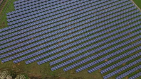 Top-down aerial view of a geometric solar panel array under dark overcast skies Video stock 340274861