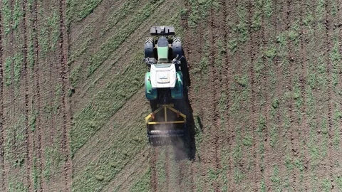 Top down aerial view of a green Fendt tractor cultivating compacted soil Stock Footage 292653075