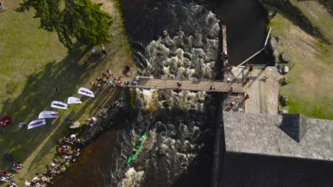 Top down aerial view of a green kayak rowing through river rapids during sunny Stock Footage 310213236