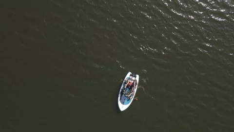 Top down aerial view of a group of people rowing and paddling on a mega large Stock Footage 307989693