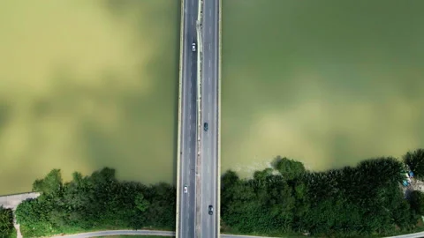 Top-down aerial view of a highway bridge crossing a muddy river. Stock Footage 311275283