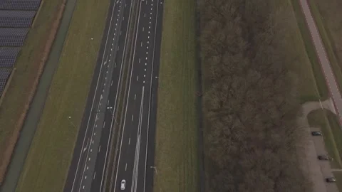 Top down aerial view of highway next to solar infrastructure Видео 330189934