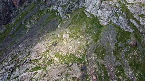 Top down aerial view of hikers on rocky mountain slope with boulders, Ala Kul Vidéo 334325992