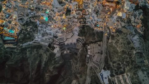 Top down aerial view of illuminated Oia village cliffside architecture at n.. Stock Photos
