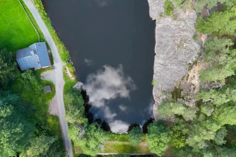 Top Down Aerial View Of Lake With Cloud Reflection And Rocky Cliff Video stock 343792878