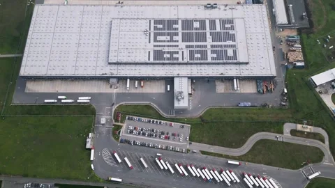 Top down aerial view of a logistics warehouse with loading docks, parked trucks Stock Footage 323439785