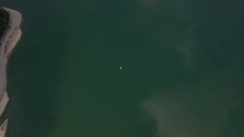 Top Down Aerial View of Lone Sailboat on Emerald Lake Water in Austria Stock Footage 340482901