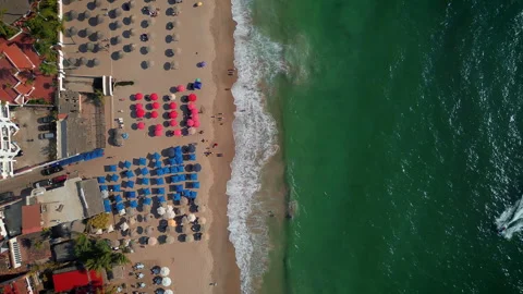 Top down aerial view of Los Muertos Beach during sunset with colorful loungers Видео 346192546