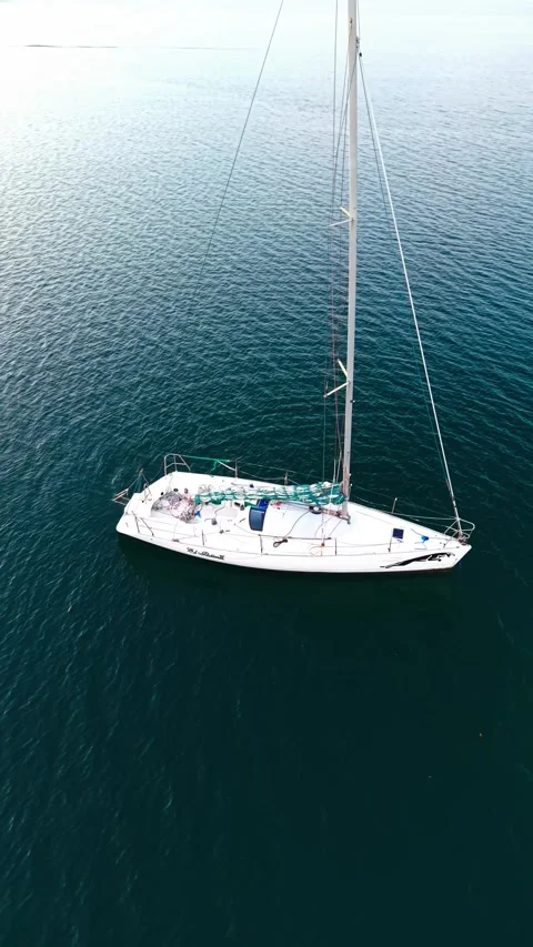 Top Down Aerial View of a Luxury Sailboat Anchored in Calm Ocean Water Stock Footage 335655596