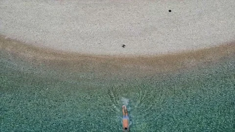 Top down aerial view of a man diving in Agios Dimitrios beach in Alonissos 스톡 동영상 135169158