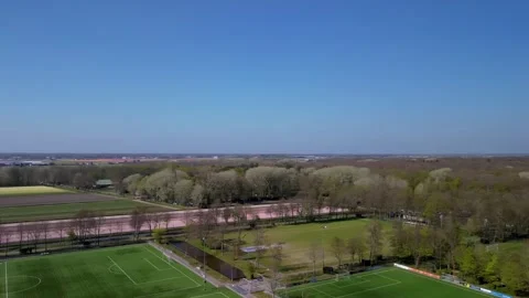 A top-down aerial view of multiple football fields surrounded by blooming tulip Stock-Footage 310195156