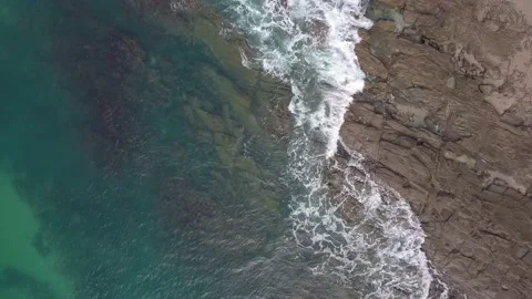 Top down aerial view of ocean waves splashing against a rocky background. Stock Footage 143620526